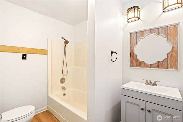 full bathroom featuring toilet, tub / shower combination, wood finished floors, and vanity