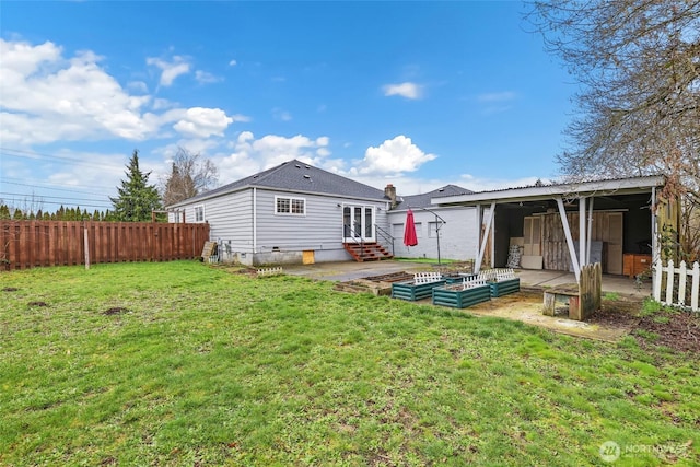 rear view of house with a lawn, entry steps, crawl space, fence, and a garden