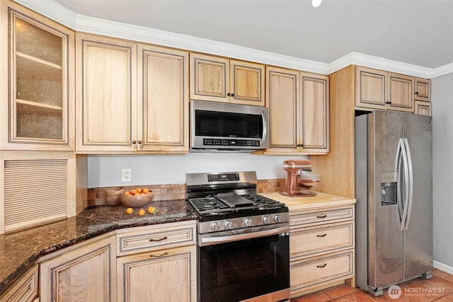 kitchen featuring glass insert cabinets, stainless steel appliances, dark stone countertops, and light tile patterned flooring