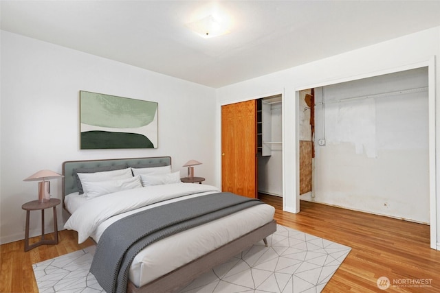 bedroom featuring light wood-style flooring and two closets