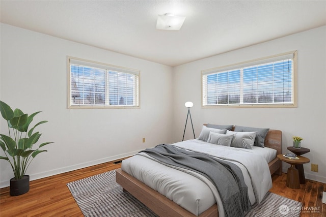 bedroom featuring baseboards and wood finished floors