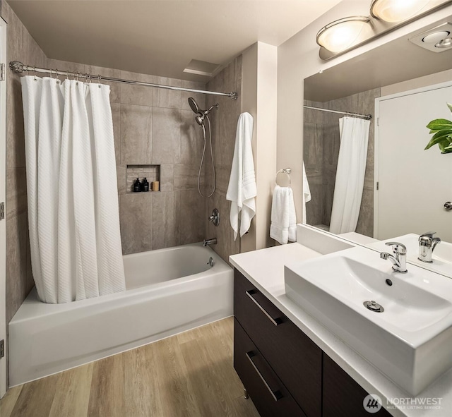 full bath featuring shower / bath combo, wood finished floors, and vanity