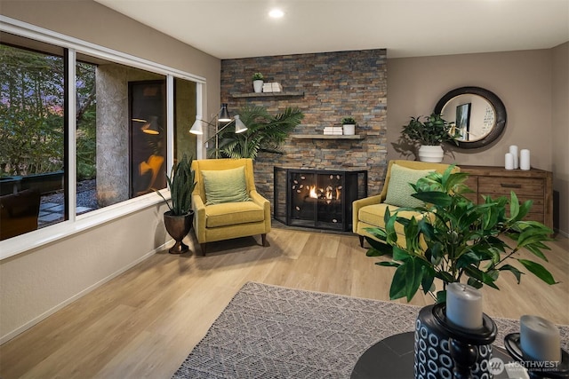 sitting room featuring a fireplace, wood finished floors, and baseboards