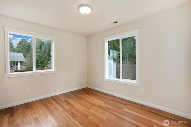 spare room with visible vents, baseboards, and light wood-style flooring