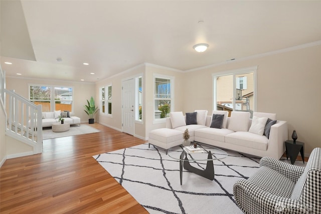 living area featuring baseboards, recessed lighting, ornamental molding, stairs, and light wood-style floors