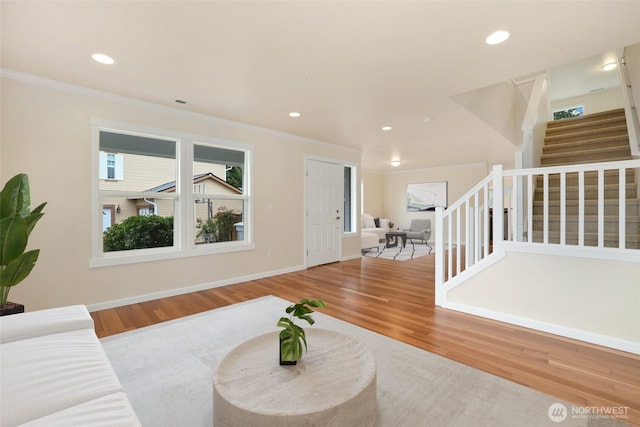 living area with stairs, recessed lighting, wood finished floors, and ornamental molding