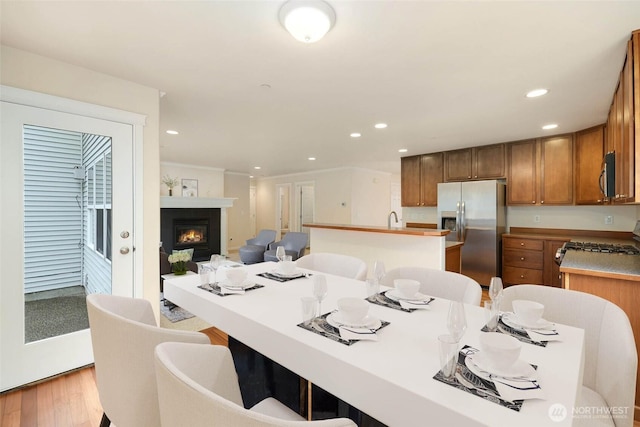 kitchen with light wood finished floors, an island with sink, recessed lighting, appliances with stainless steel finishes, and open floor plan