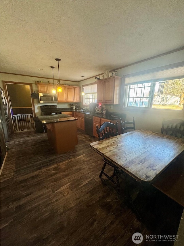 kitchen featuring dark countertops, dark wood-style floors, a center island, stainless steel appliances, and a textured ceiling