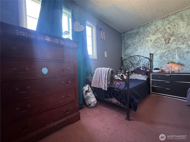 bedroom with lofted ceiling, dark colored carpet, and wallpapered walls