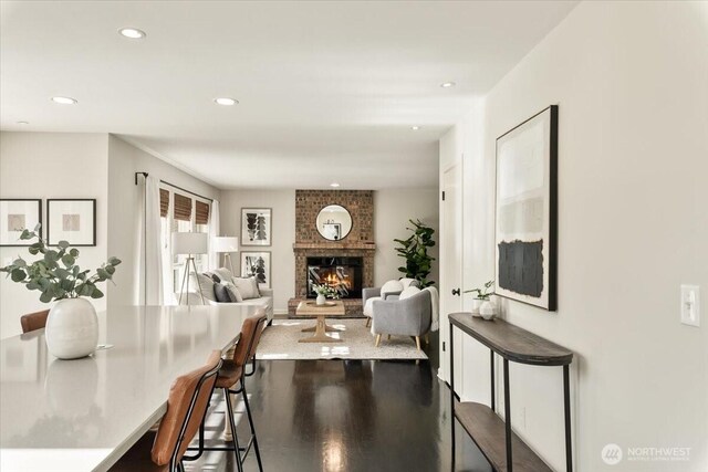 dining area featuring wood finished floors, recessed lighting, and a fireplace