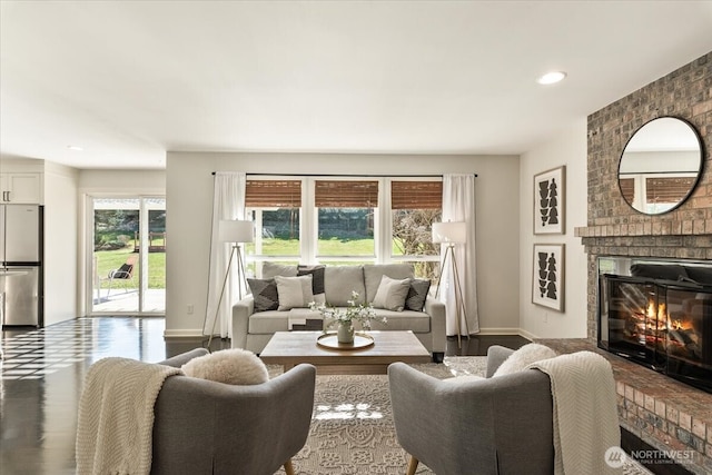 living room featuring a wealth of natural light, a fireplace, baseboards, and wood finished floors