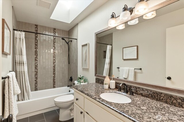 bathroom featuring visible vents, a skylight, tile patterned floors, vanity, and shower / bathtub combination with curtain