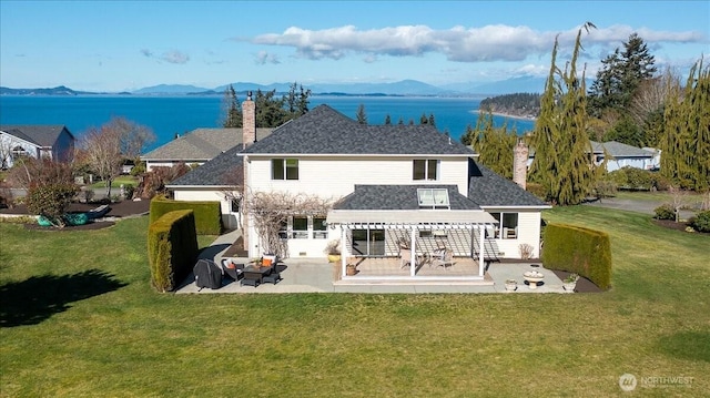 back of property with a patio area, a mountain view, and a chimney