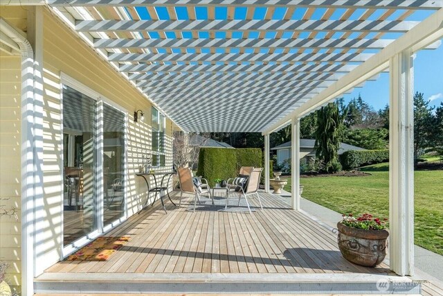 wooden terrace featuring a lawn and a pergola