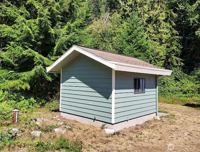 view of shed featuring a view of trees