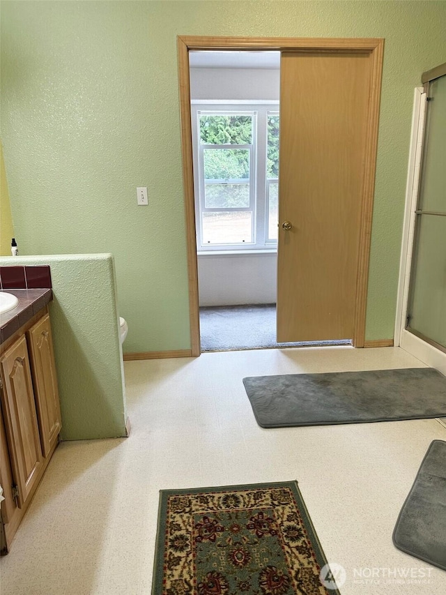 full bath featuring toilet, tile patterned floors, an enclosed shower, and vanity