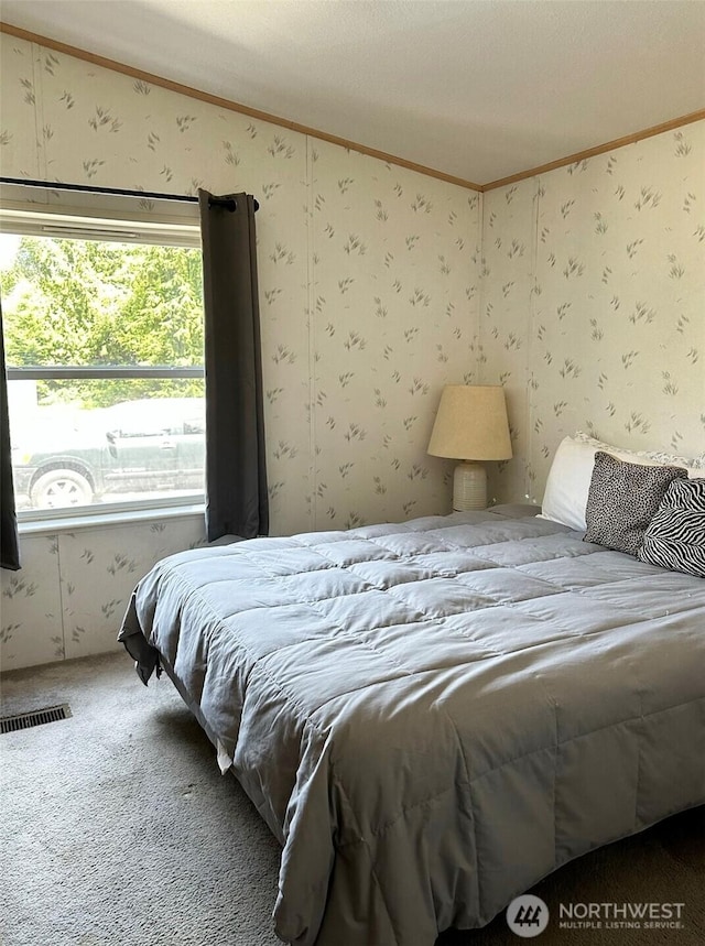 carpeted bedroom featuring crown molding and wallpapered walls