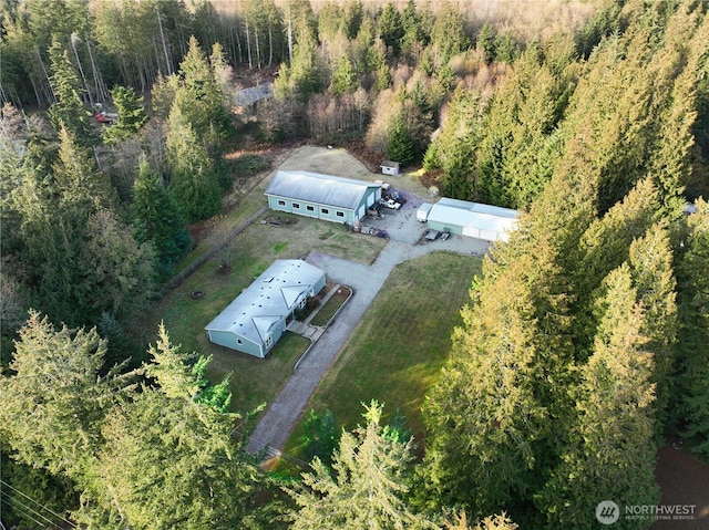 birds eye view of property featuring a forest view