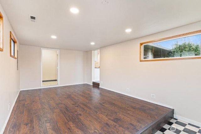 empty room featuring wood finished floors, recessed lighting, visible vents, and baseboards