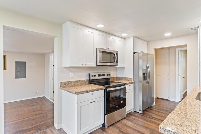 kitchen with electric panel, stainless steel appliances, dark wood-style floors, and white cabinets