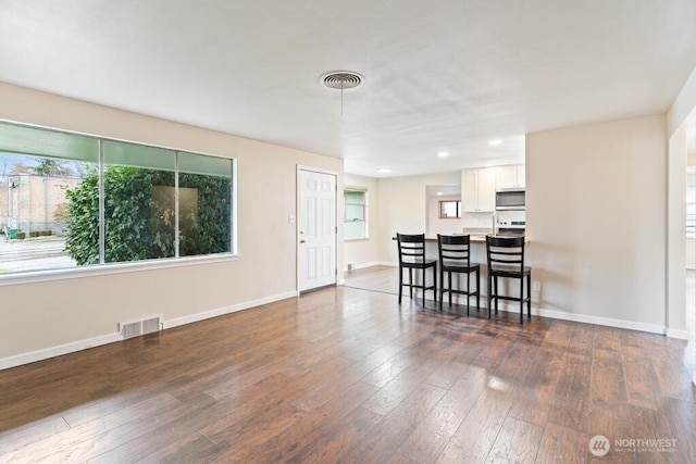 interior space with visible vents, baseboards, and dark wood-style flooring