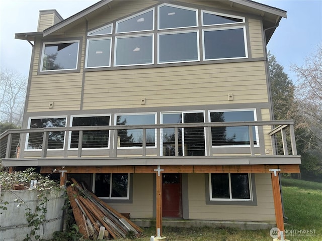 rear view of house featuring a chimney and a deck