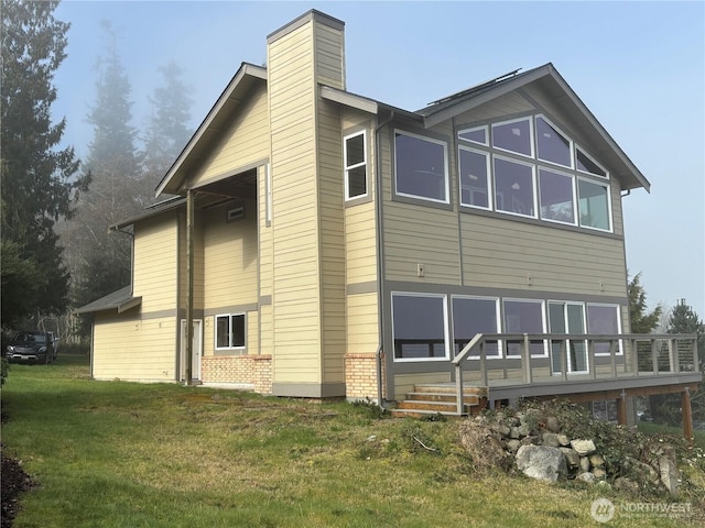 2459 Bretland Rd, Camano Island, WA 98282 - rear view of property featuring a yard, brick siding, a wooden deck, and a chimney