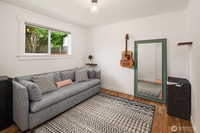 living area featuring baseboards and wood finished floors