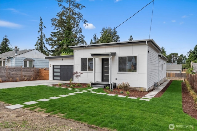 view of front of home featuring an attached garage, fence, a front lawn, and concrete driveway