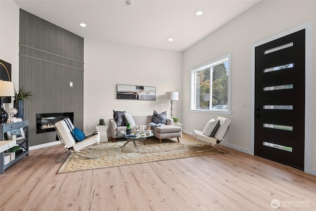 sitting room featuring recessed lighting, a large fireplace, baseboards, and wood finished floors