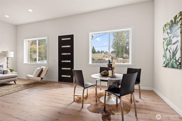 dining room with baseboards, wood finished floors, and recessed lighting