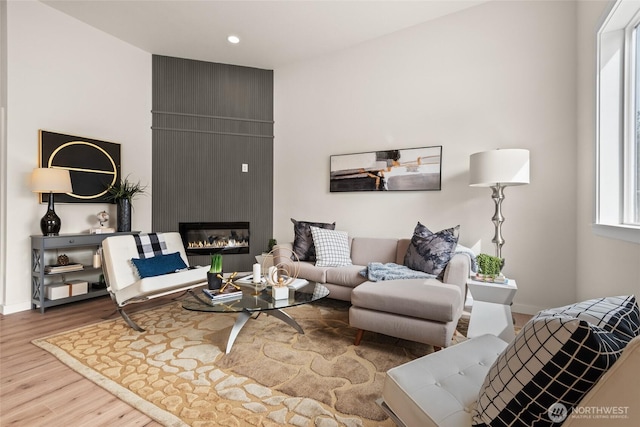 living area with recessed lighting, a fireplace, wood finished floors, and baseboards