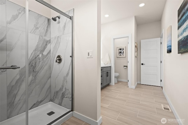 bathroom with a marble finish shower, visible vents, toilet, wood tiled floor, and vanity