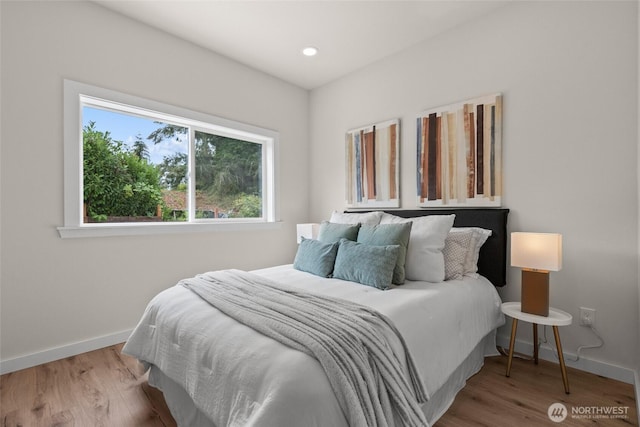 bedroom with baseboards, wood finished floors, and recessed lighting