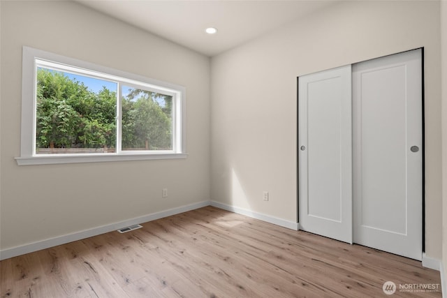 unfurnished bedroom with recessed lighting, a closet, visible vents, light wood-style floors, and baseboards