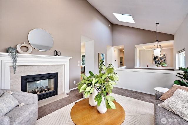 9418 NE Tidal Ct, Bainbridge Island, WA 98110 - living area featuring a tiled fireplace, carpet, high vaulted ceiling, and a skylight