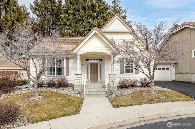 view of front facade featuring a garage and aphalt driveway