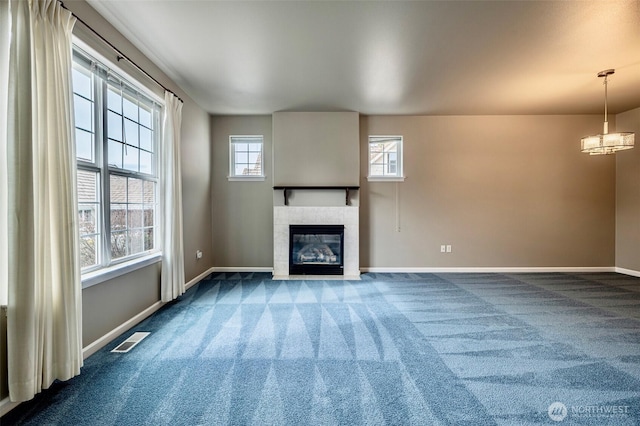 unfurnished living room with a fireplace, carpet flooring, visible vents, and baseboards