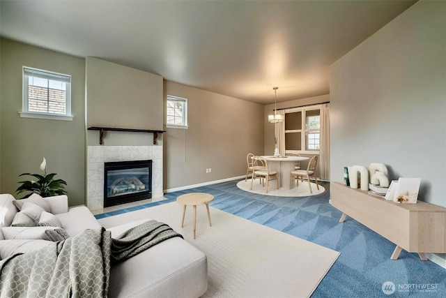 living room with carpet floors, a healthy amount of sunlight, baseboards, and a tile fireplace