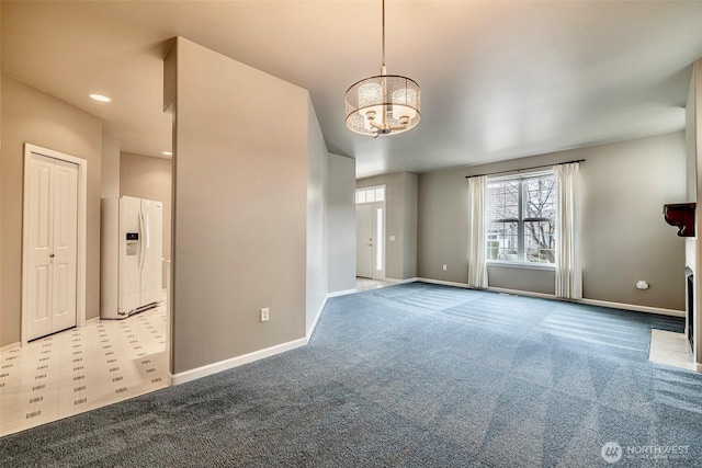 carpeted empty room featuring recessed lighting, a notable chandelier, and baseboards