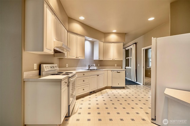 kitchen featuring white appliances, light countertops, under cabinet range hood, a sink, and recessed lighting