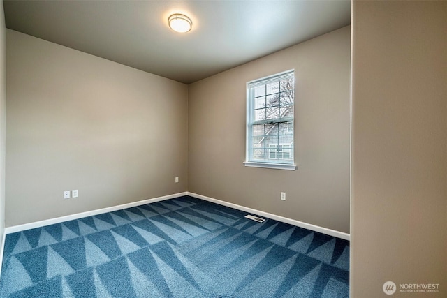 unfurnished room featuring dark colored carpet, visible vents, and baseboards