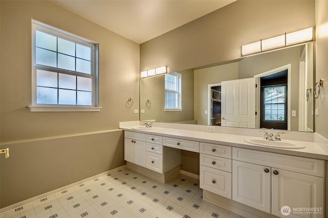 full bathroom with double vanity, plenty of natural light, and a sink