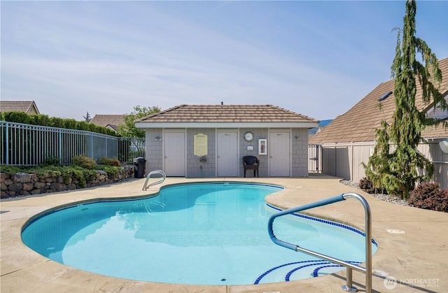 view of pool featuring a patio area, a fenced backyard, an outdoor structure, and a fenced in pool