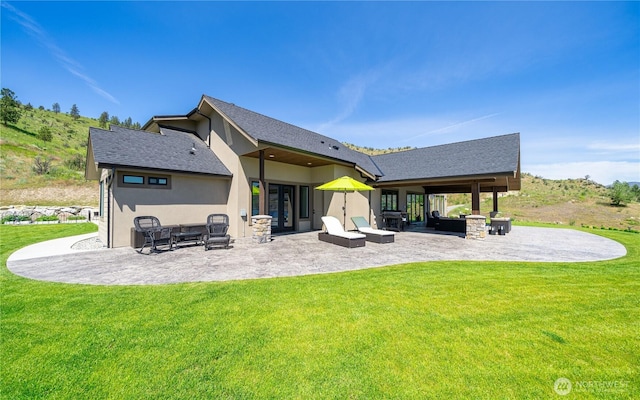 rear view of house featuring french doors, stucco siding, a yard, and a patio