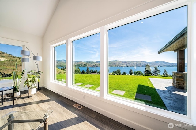 sunroom / solarium with lofted ceiling, visible vents, and a water and mountain view