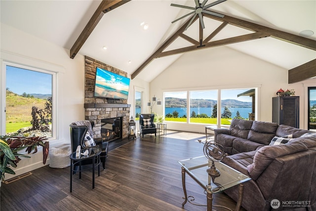 living room featuring visible vents, wood finished floors, a stone fireplace, high vaulted ceiling, and beam ceiling