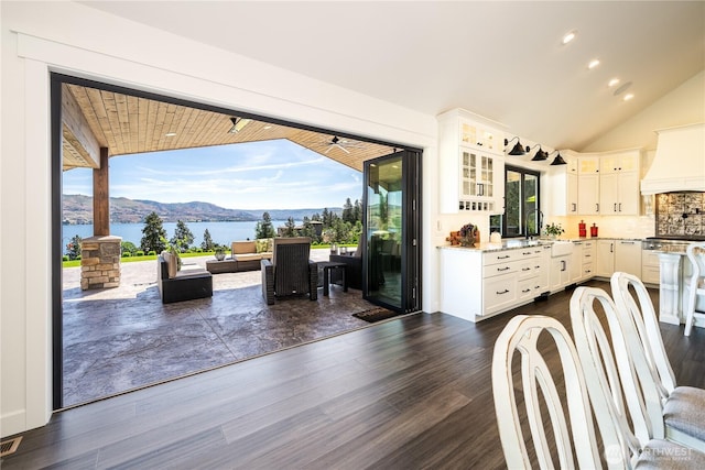 kitchen with dark wood-type flooring, lofted ceiling, stainless steel electric range, and custom exhaust hood