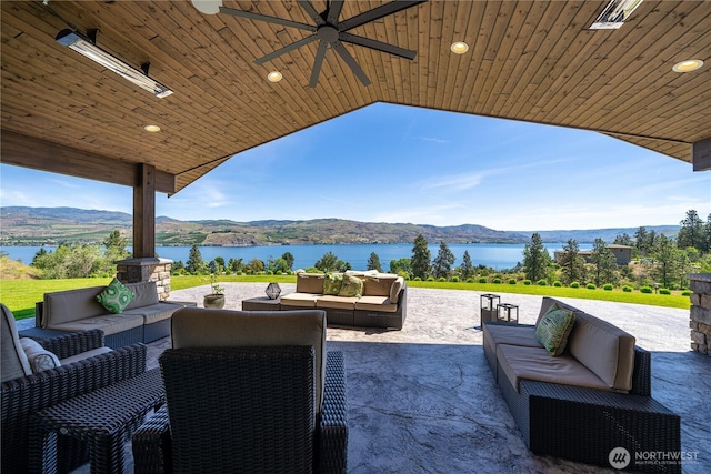 view of patio / terrace featuring a water and mountain view and an outdoor living space