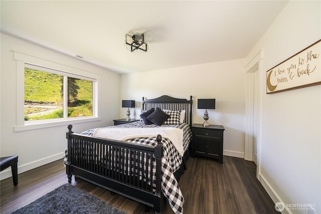 bedroom with dark wood-style flooring and baseboards